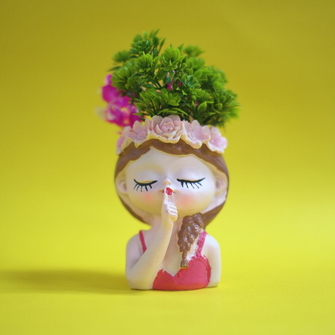 Decorative vase shaped like a girl with a plant on a yellow background