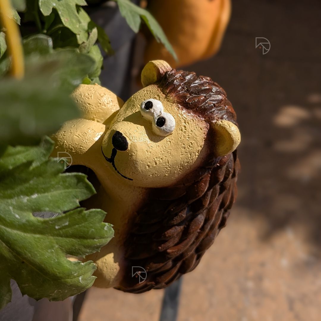Resin hedgehog pot hanger on grey planter with yellow trellis — terrace garden decoration India