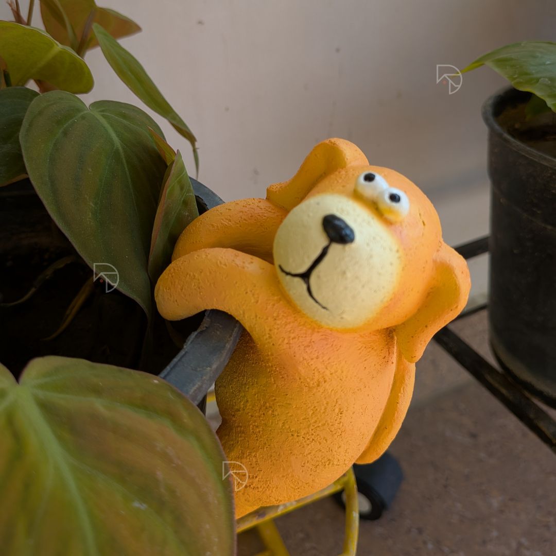 Climbing dog garden ornament on dark plastic pot — outdoor resin figurine for balcony décor