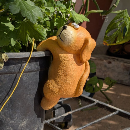 Resin dog pot hanger on garden planter — rear view showing full body and hanging legs