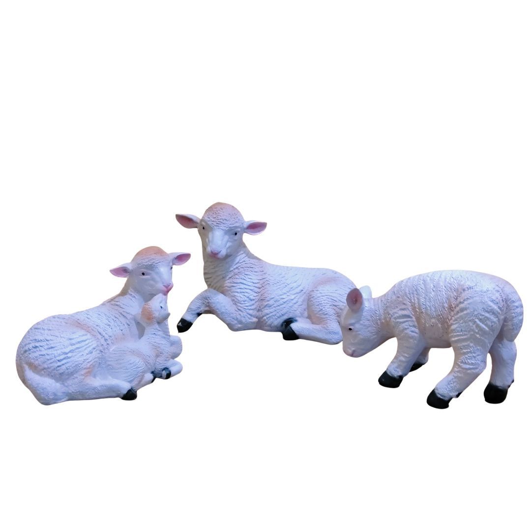 Three white sheep figurines on a white background