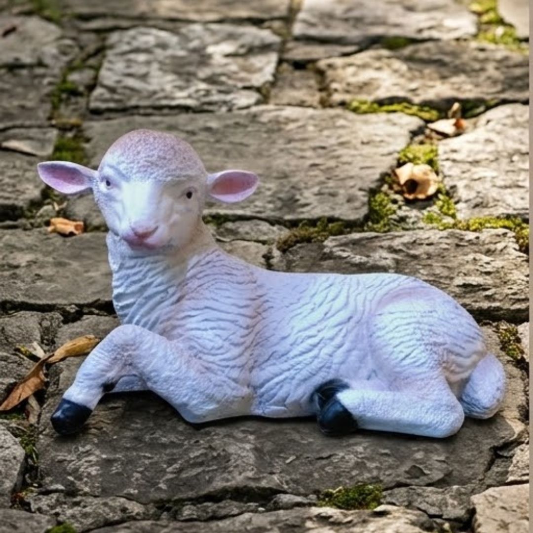 White sheep figurine lying on a stone surface