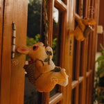 Plush toy rabbit hanging on a wooden door with blurred background
