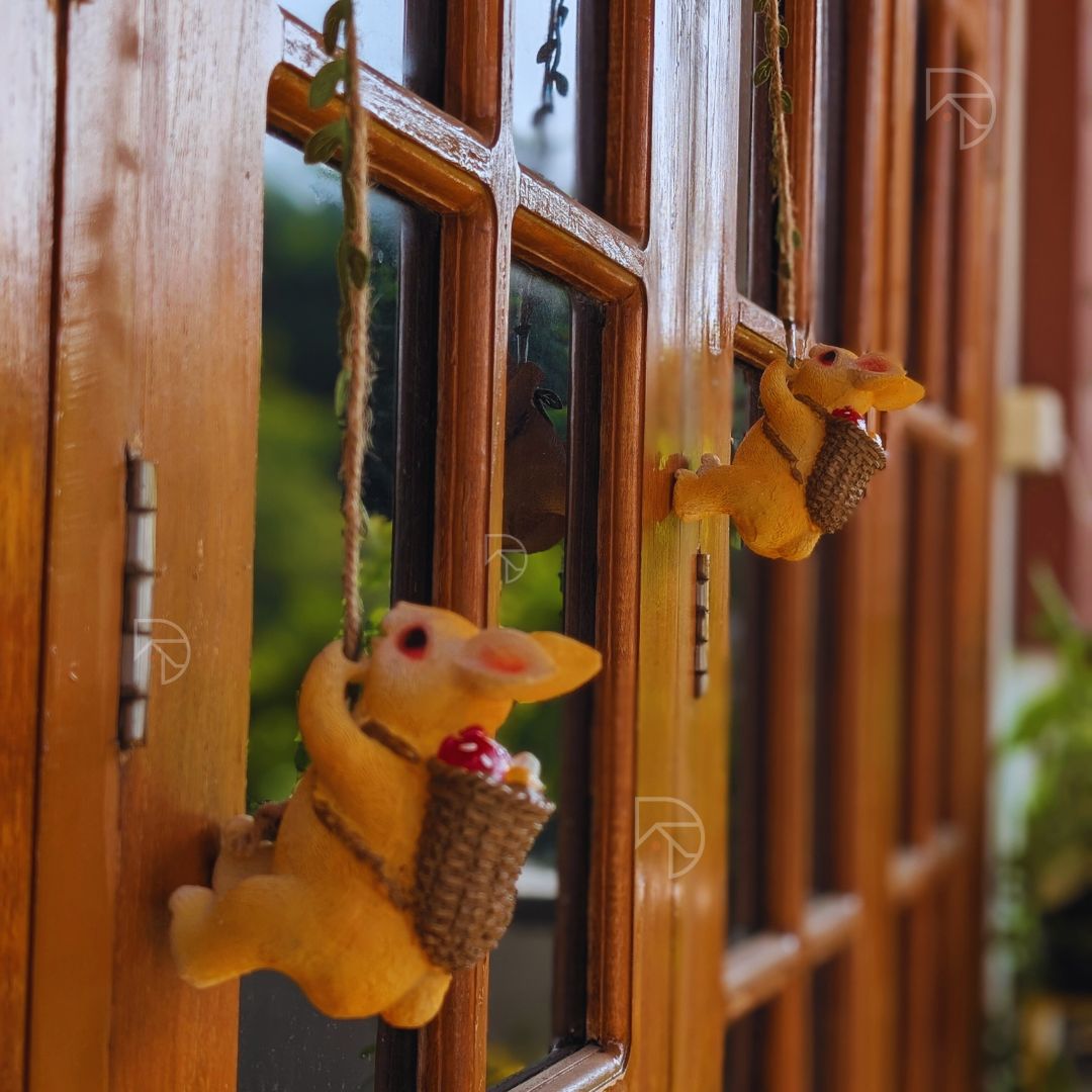 Yellow plush toy rabbit hanging from a string on a wooden door