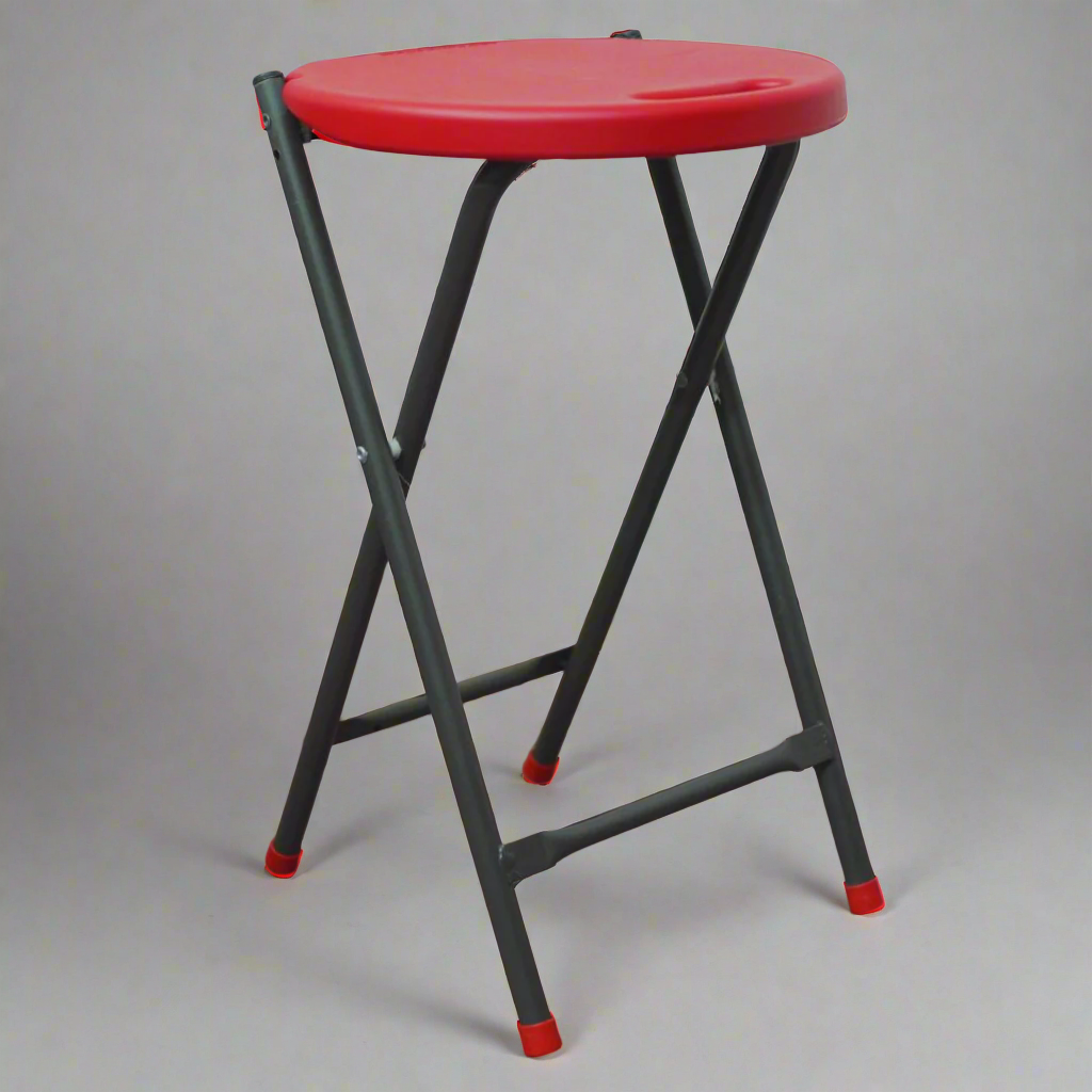 Red stool with black legs on a wooden floor against a textured wall.