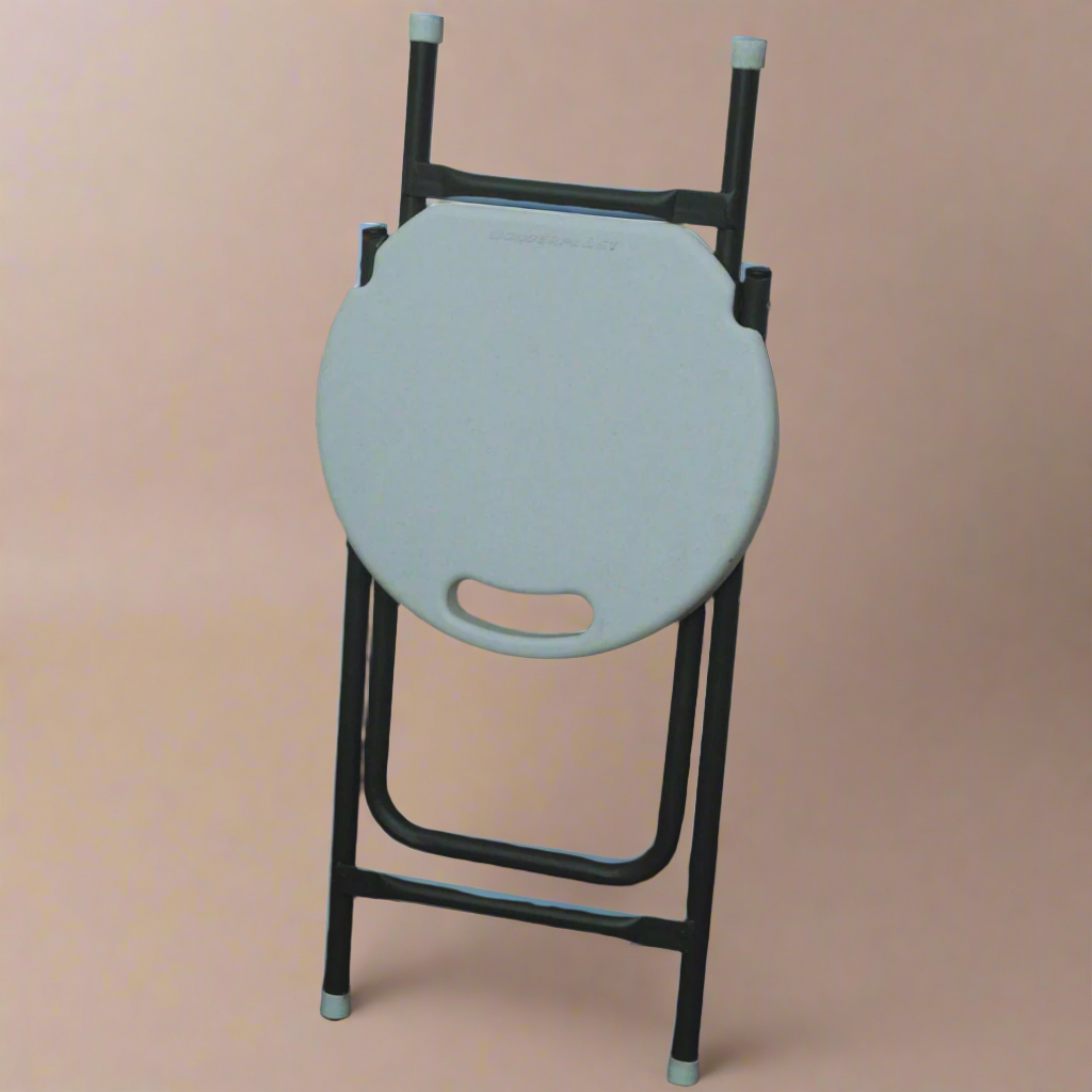 White round stool with black metal frame against a textured wall.