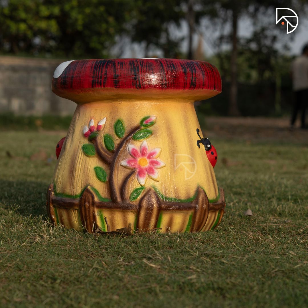 Decorative mushroom-shaped stool with floral design on grass