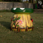 Decorative garden stool with floral and ladybug design on grass