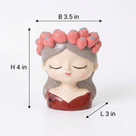 A small decorative figurine of a sleeping girl with a pink floral crown, gray hair, and a red dress, shown on a white background with dimension labels indicating B 3.5 in, H 4 in, and L 3 in.