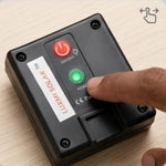 A close-up of a black Luxin Solar portable solar light being turned on by a person's finger, with a red power button and a green indicator light visible.