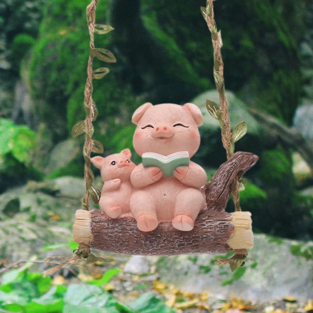 Two pink pig figurines on a swing with a green background