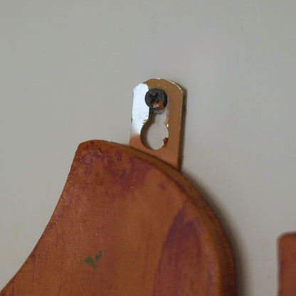 Wooden cutting board with a metal hook on a plain wall