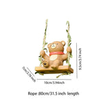 Decorative bear figurine on a swing with measurements on a white background