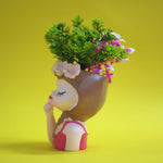 Decorative figurine of a girl with flowers in her hair on a yellow background