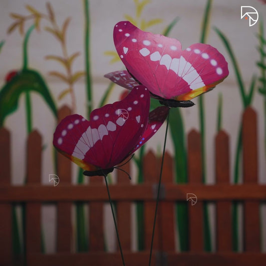 Pink butterfly-shaped windsock with a blurred garden background