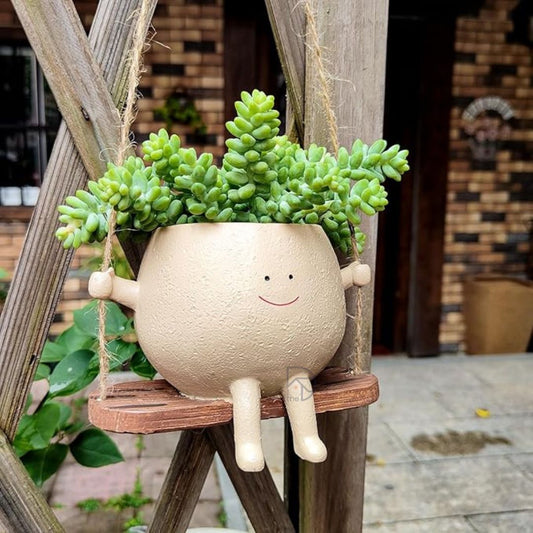 Smiley Face Swing Planter made of durable resin, featuring a cheerful face design on a hanging swing, perfect for indoor and outdoor decor, small plants like succulents, and gifting occasions like Mother’s Day or Teacher Appreciation.