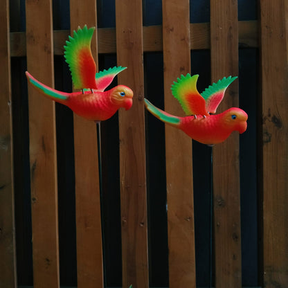 Two colorful parrot-shaped objects against a wooden background