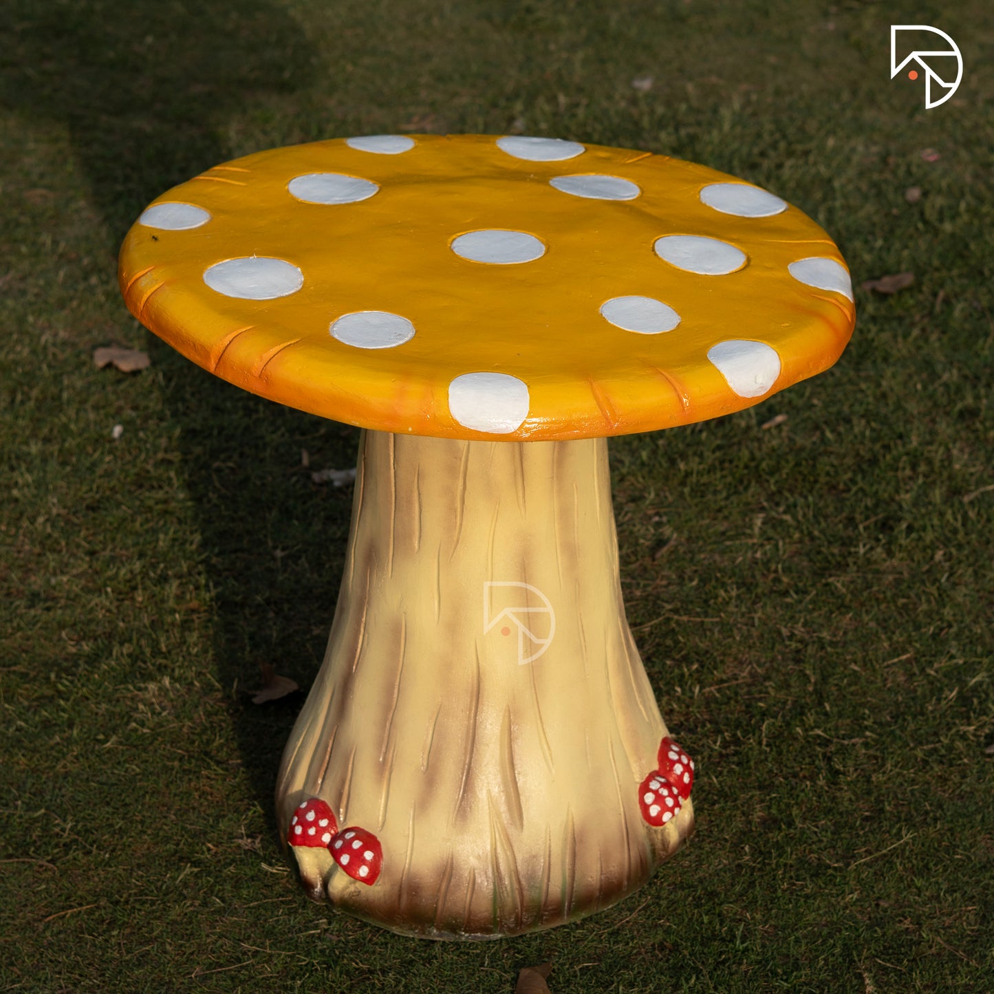 Mushroom-shaped stool with a yellow polka dot cap on a grassy background