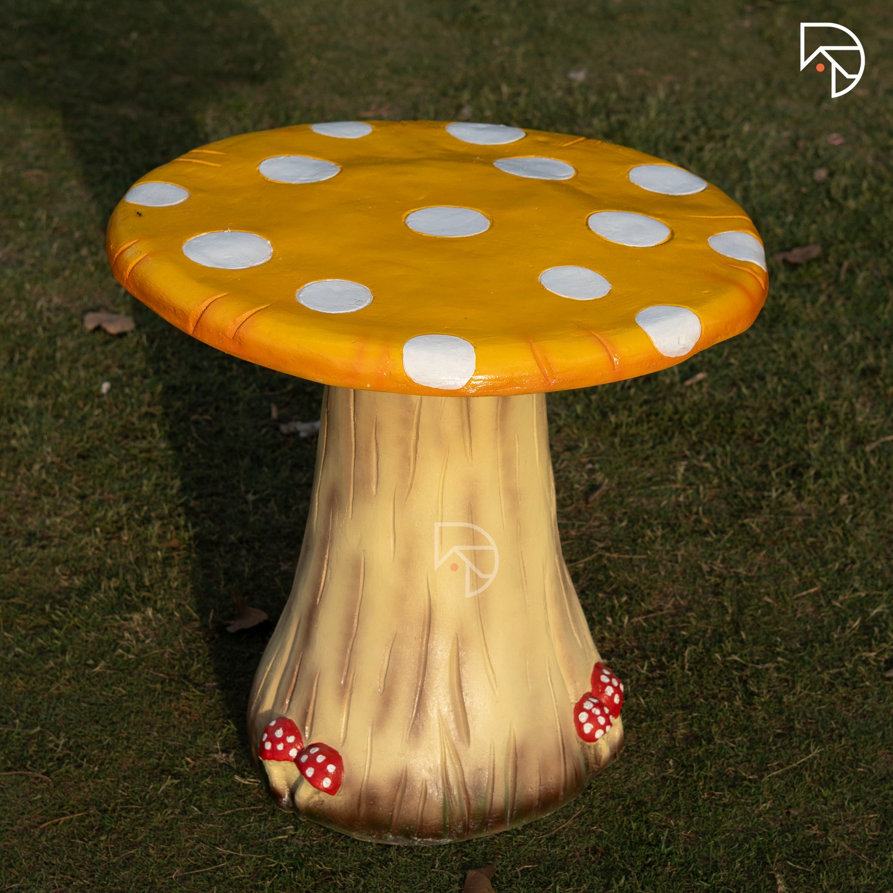 Mushroom-shaped stool with a yellow polka dot cap on a grassy background